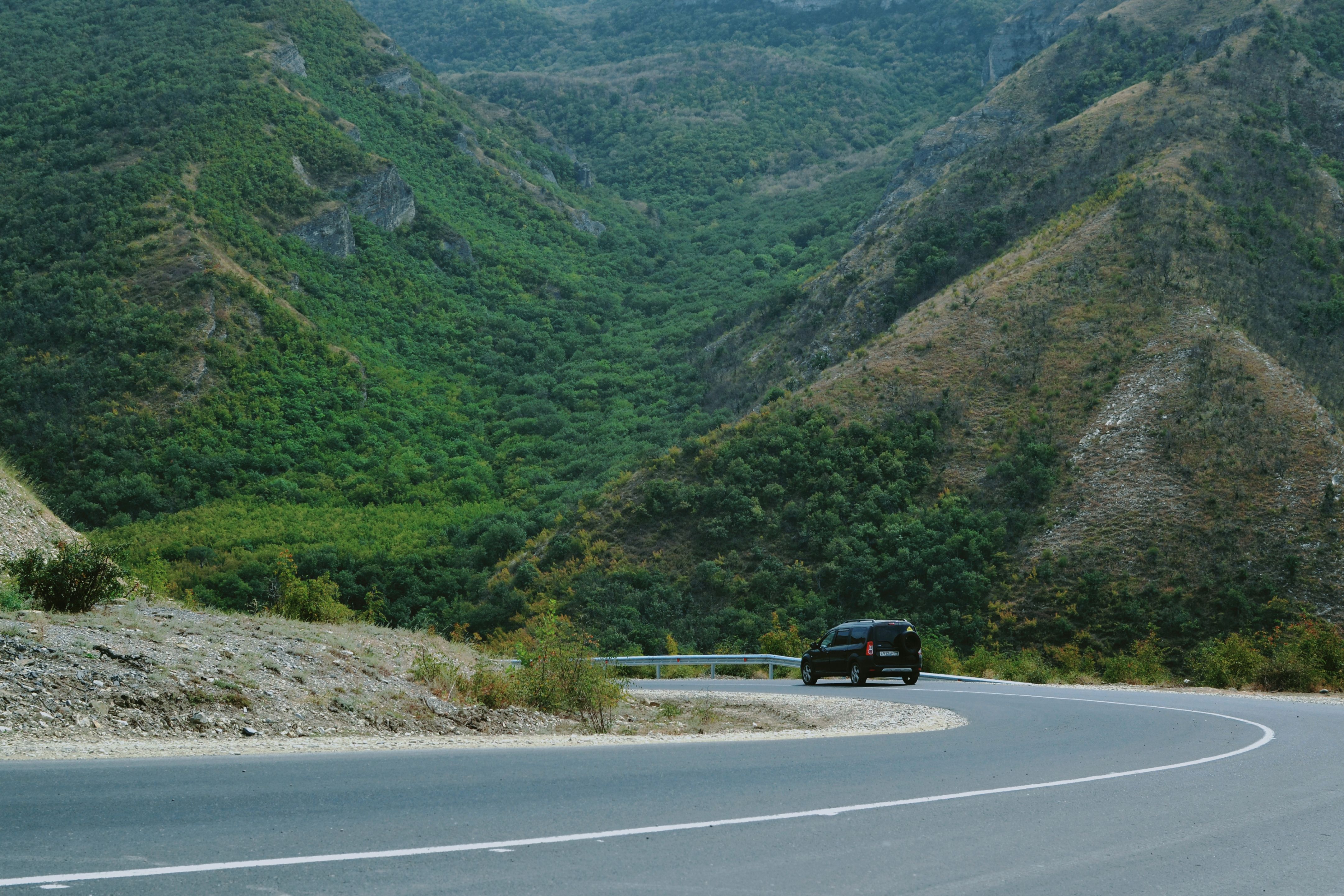 A car navigating a winding mountain road, illustrating careful cornering in everyday driving.