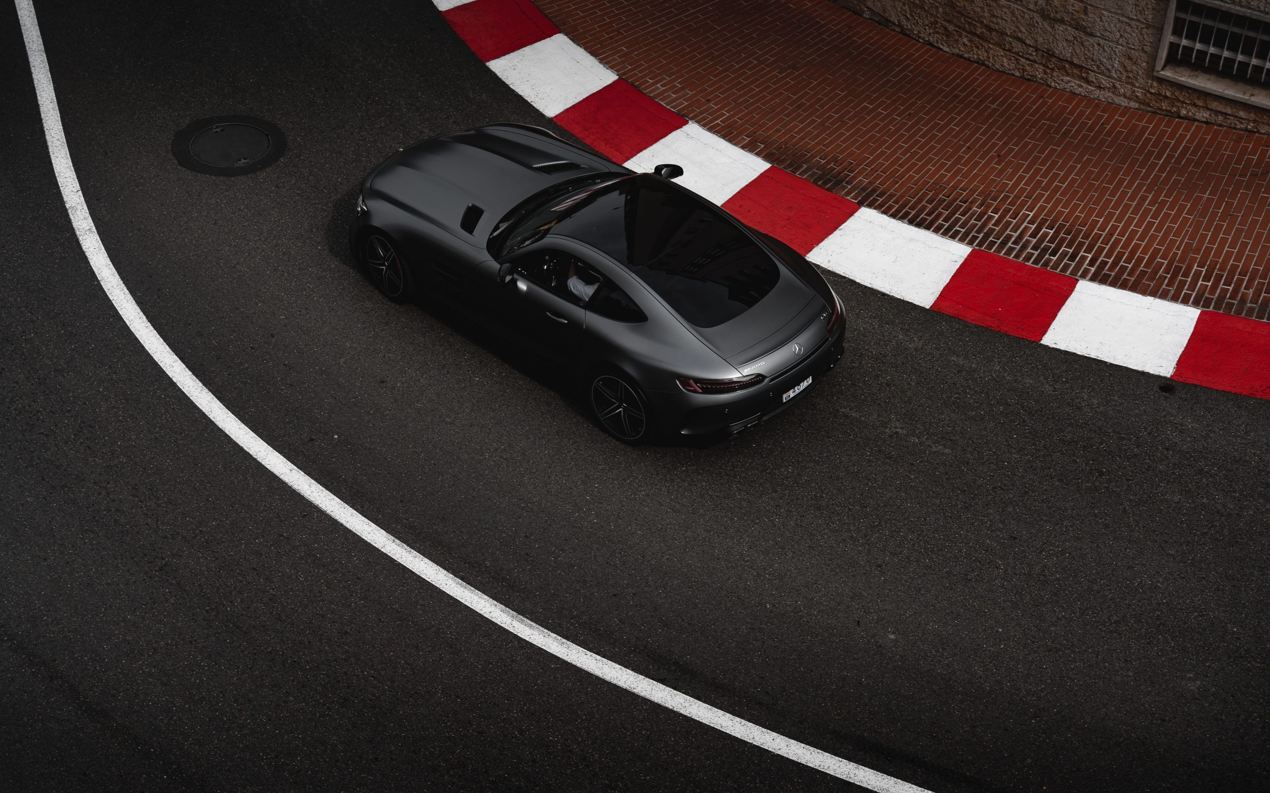 Overhead view of a car following the curve of a race track, illustrating the racing line and corner apex.