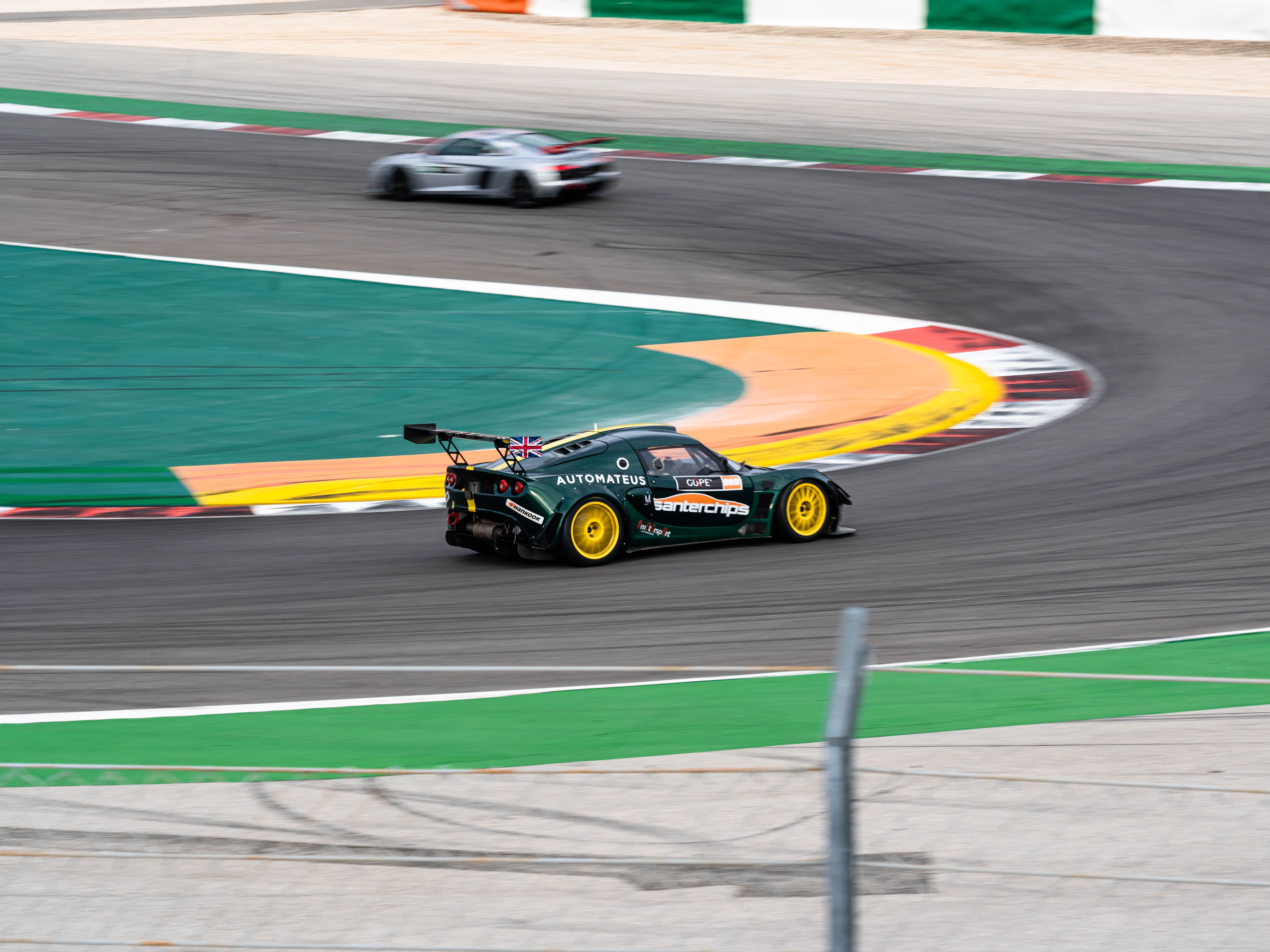 Race cars negotiating a circuit turn, showing how drivers position for a fast corner exit.